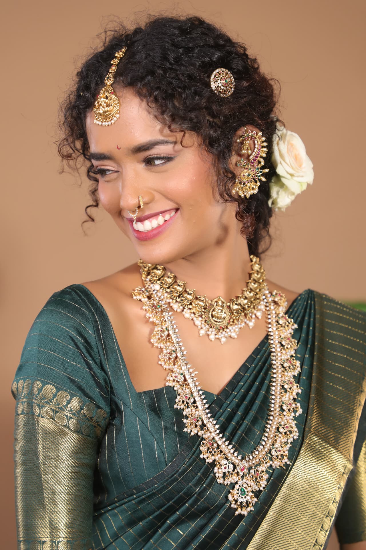 Traditional bride in green silk saree with curly hairstyling