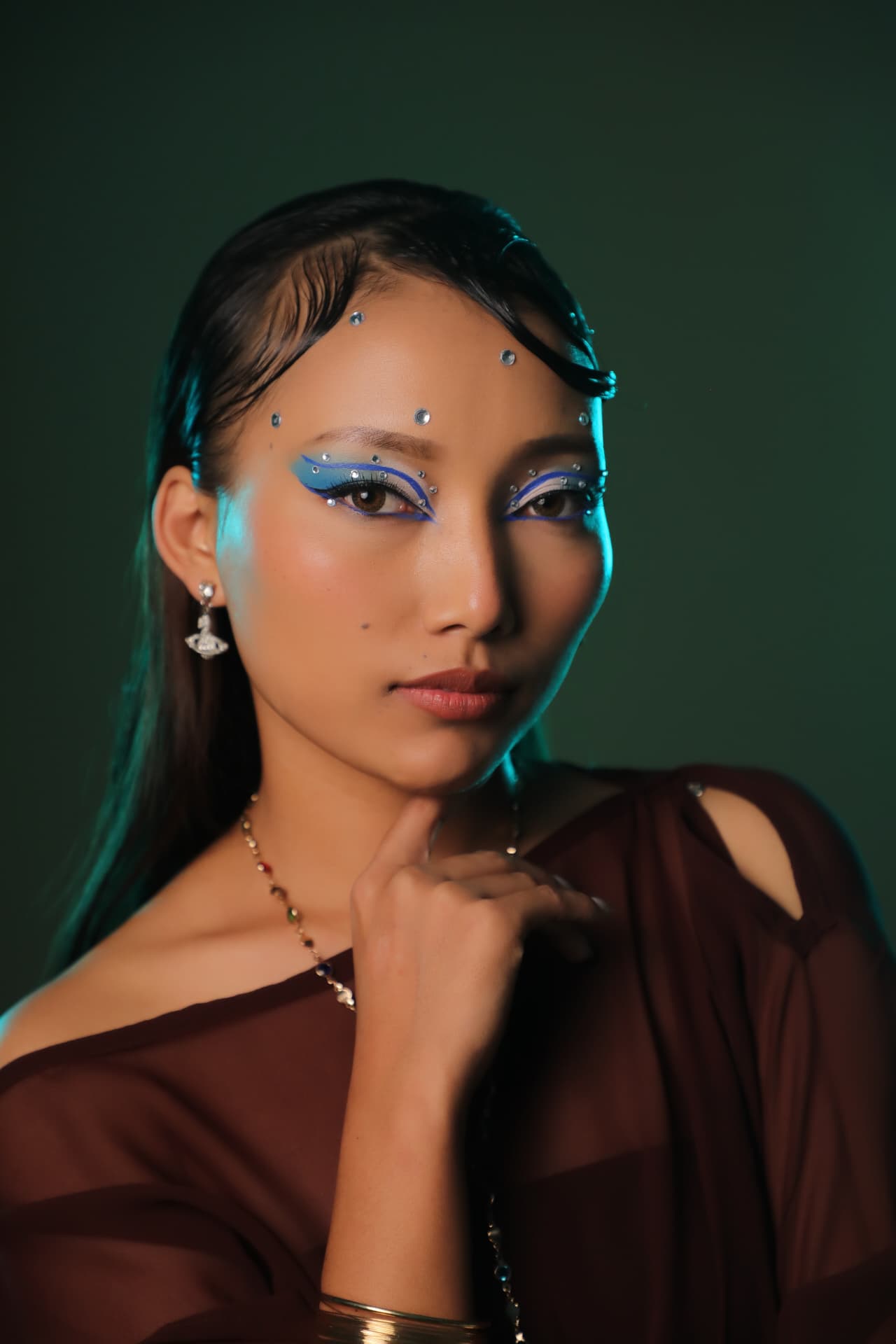 Editorial blue graphic liner makeup with crystals
